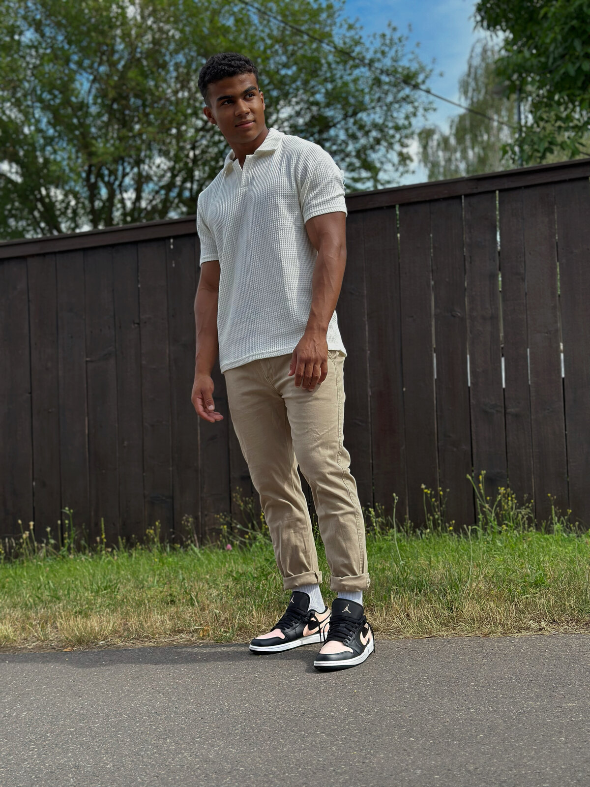 Maximus in a white polo and beige chinos, outdoor fashion shot