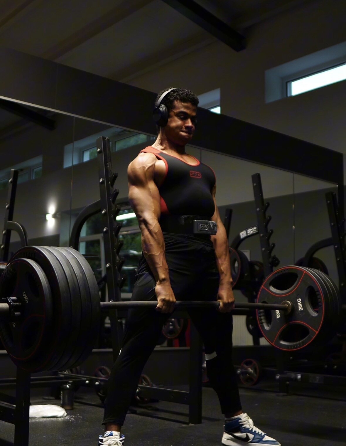 Maximus deadlifting a loaded barbell in SBD gear